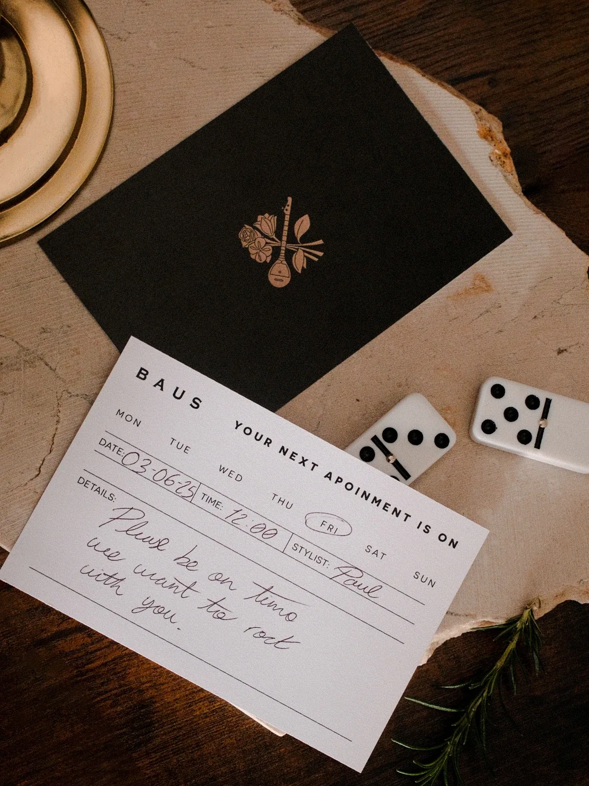 Baus appointment card and black envelope with dominoes and rosemary