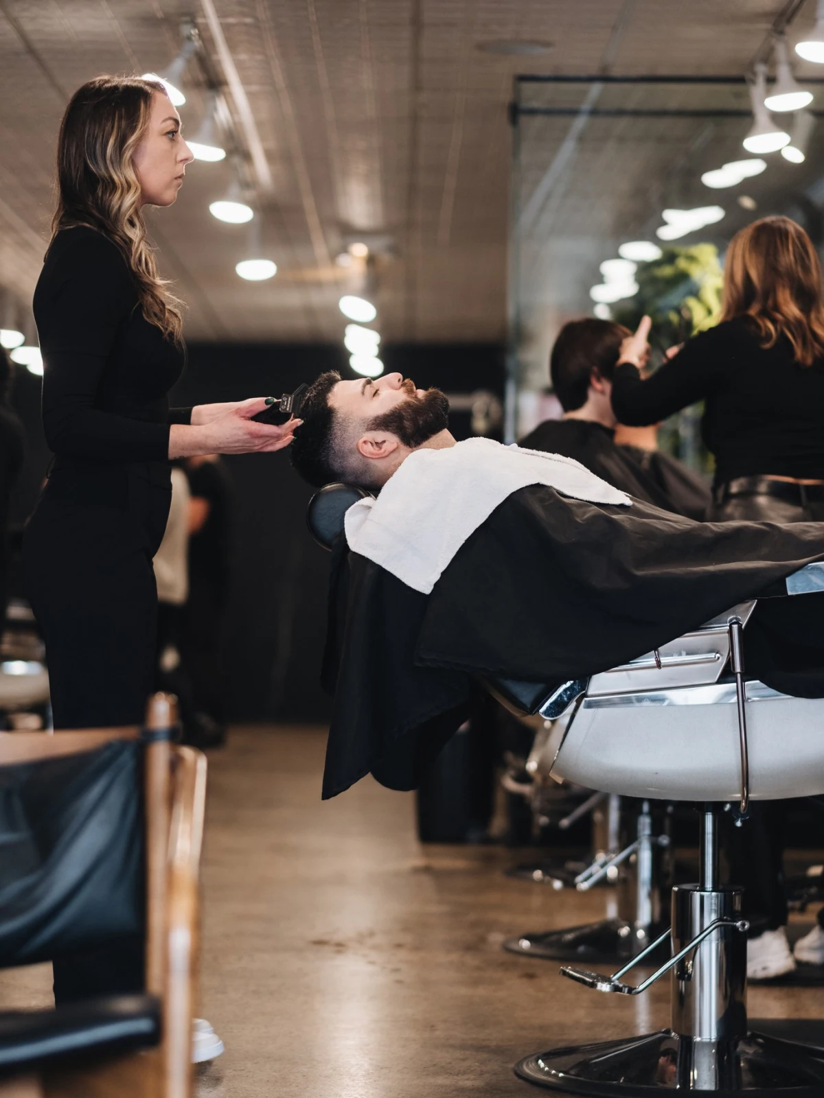 Barber cutting a client's hair inside the Baus barbershop