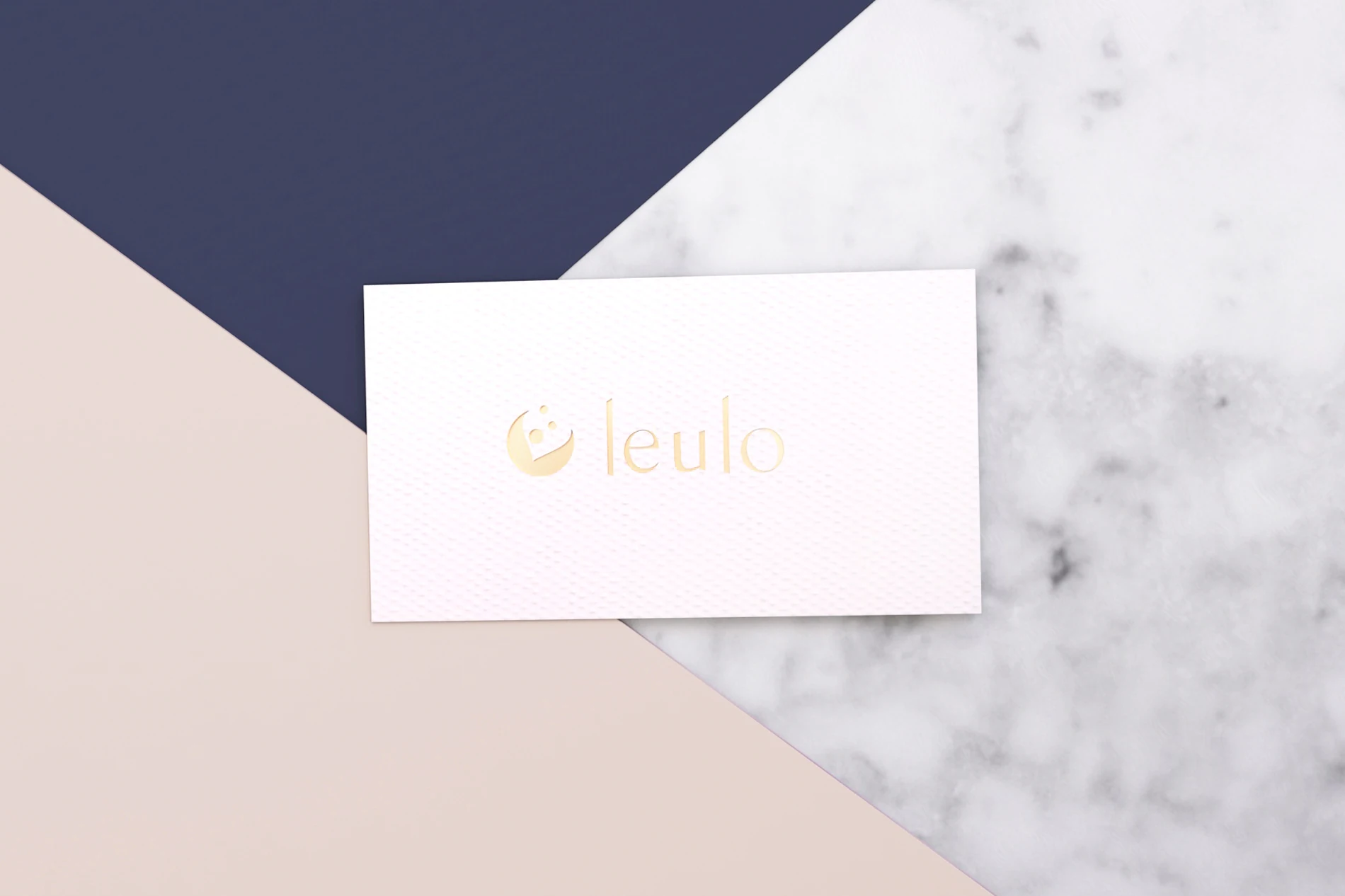 Tarjeta de presentación de Leulo con logo dorado sobre rosa, azul marino y mármol