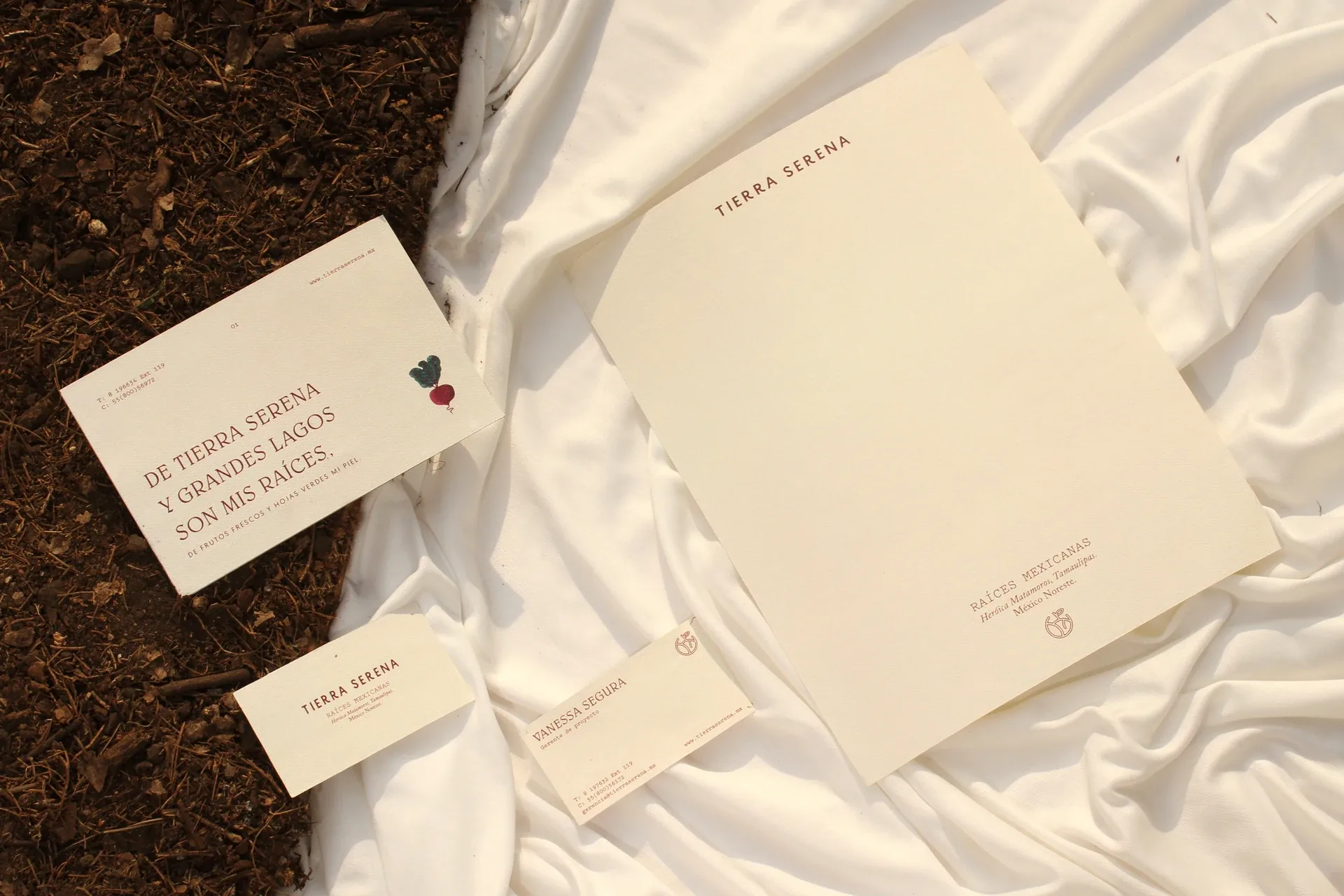 Tierra Serena stationery on white fabric and soil