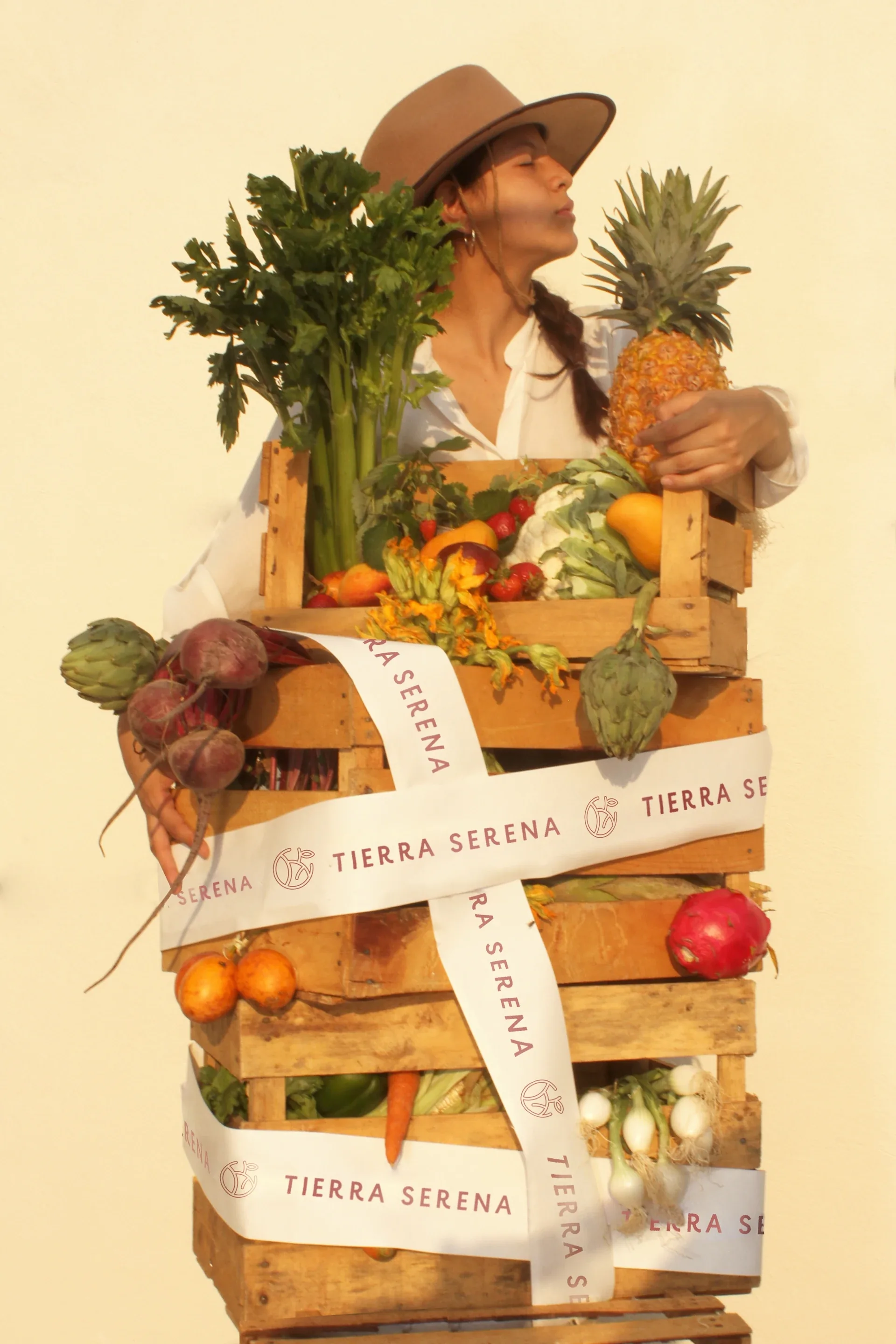 Woman holding a crate of produce wrapped in Tierra Serena ribbon
