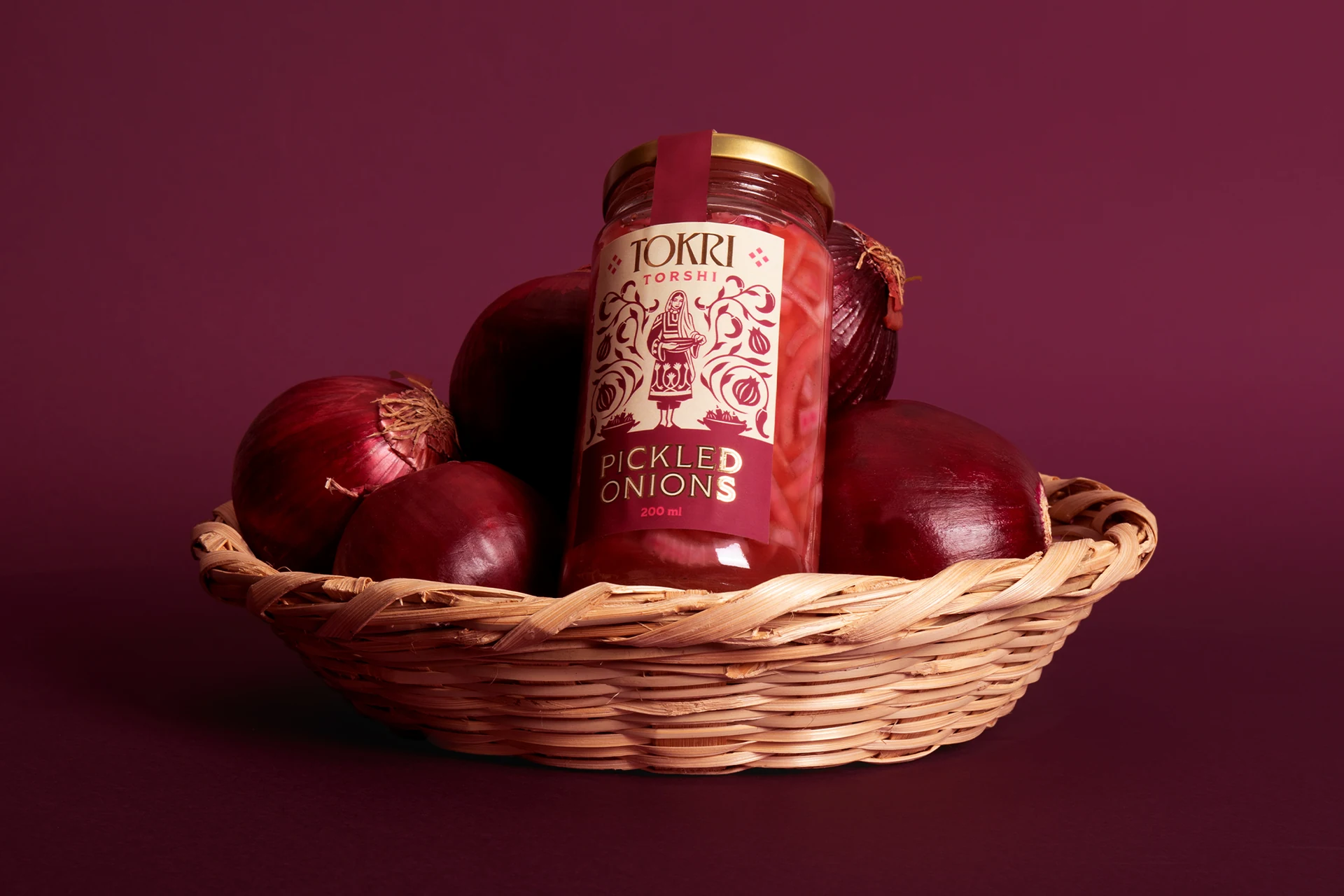 Tokri pickled onions jar in a wicker basket with red onions